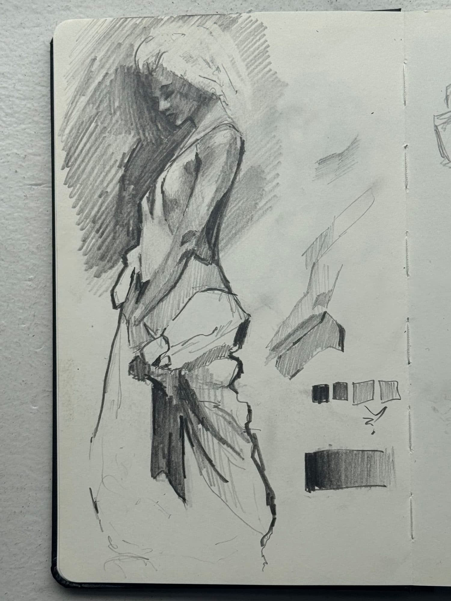 Graphite figure study of a woman looking down, heavy diagonal hatching behind her, with value-scale swatches at the side.